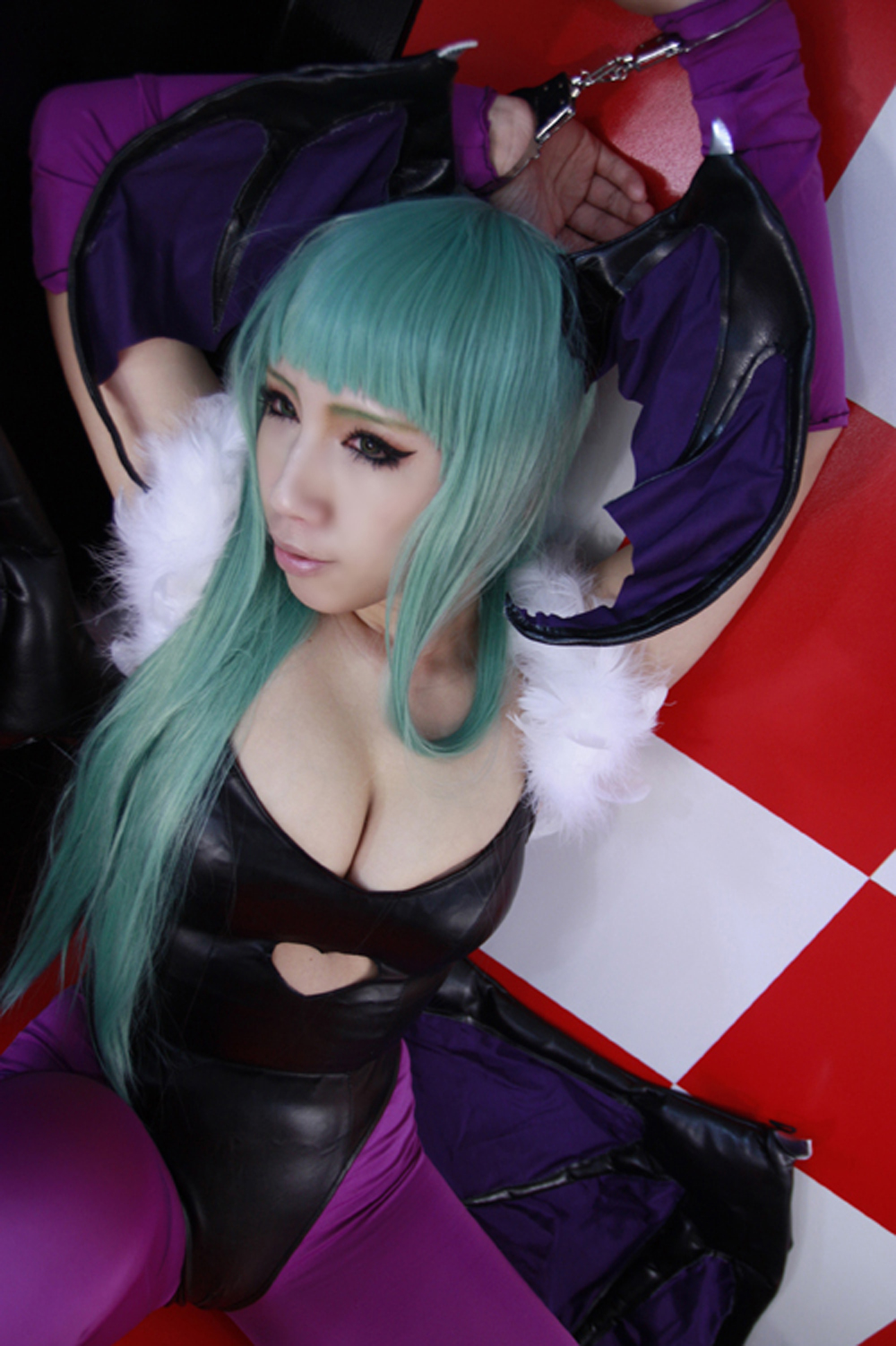 asian bare_shoulders breasts capcom cleavage cosplay darkstalkers female green_hair handcuffs large_breasts leotard long_hair looking_away morrigan_aensland nonsummerjack solo succubus tight_fit wings