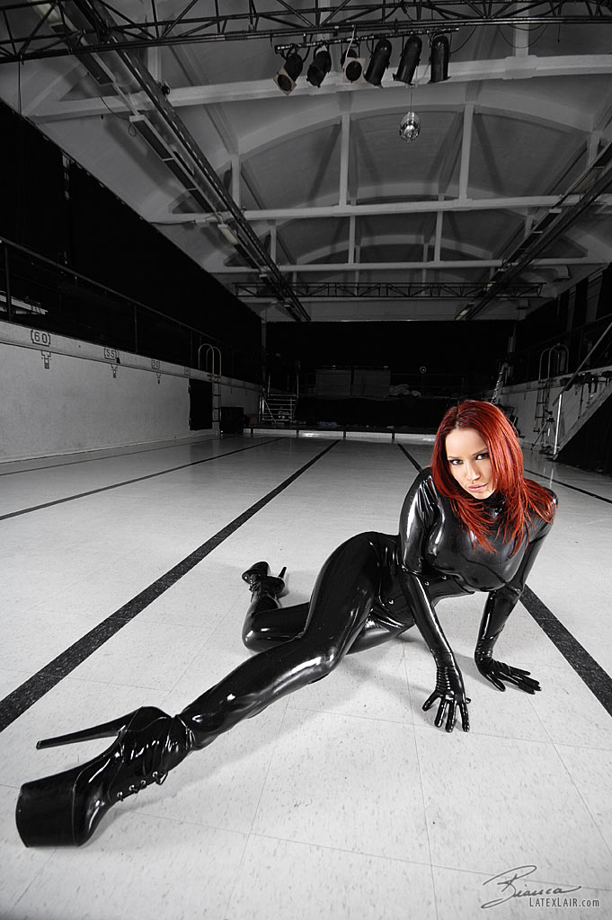 bianca_beauchamp breasts catsuit female gloves high_heels large_breasts latex long_hair red_hair shoes solo watermark