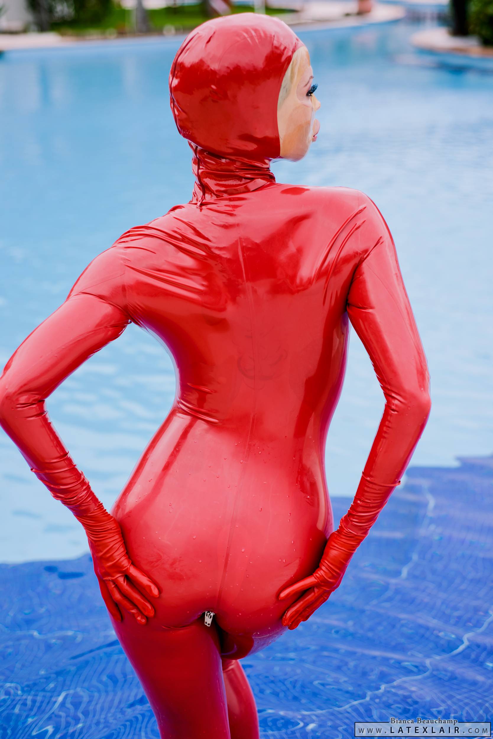ass bianca_beauchamp breasts catsuit female gloves large_breasts latex long_hair looking_back mask pool red_hair solo water watermark wet