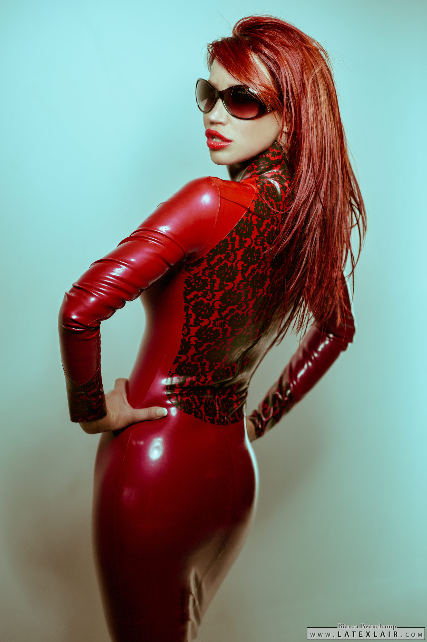 ass bianca_beauchamp breasts dress female large_breasts latex lipstick long_hair looking_back red_hair simple_background solo sunglasses watermark