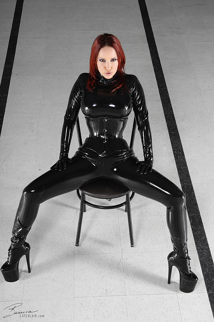 bianca_beauchamp breasts catsuit female gloves high_heels large_breasts latex long_hair red_hair shoes solo watermark