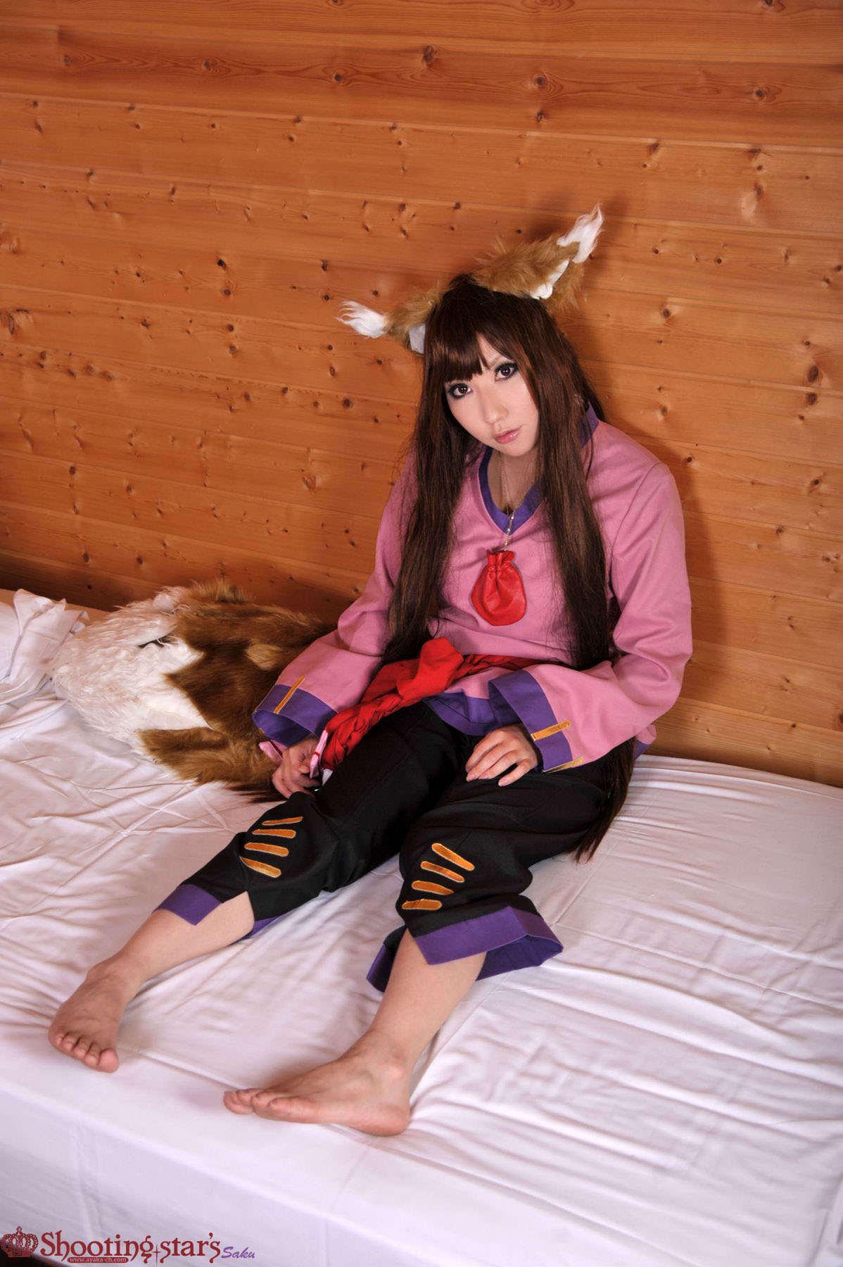 1girl animal_ears asian bed breasts brown_hair cosplay female holo japanese long_hair on_bed shooting_star solo spice_and_wolf watermark wolf_ears