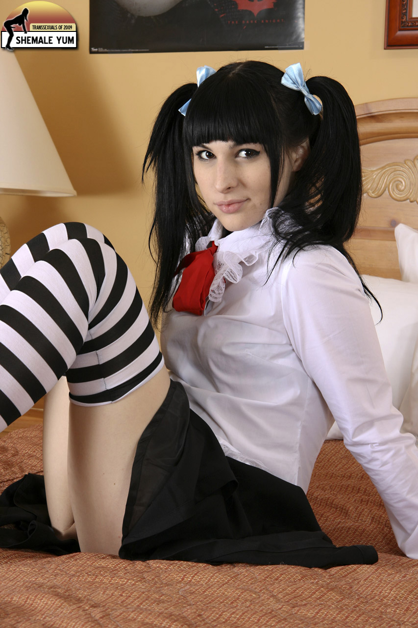 bailey_jay black_hair bow breasts clothed long_hair looking_at_viewer non-nude on_bed porn_star schoolgirl shemale shemaleyum sitting smirk solo stockings thighhighs transgender watermark white