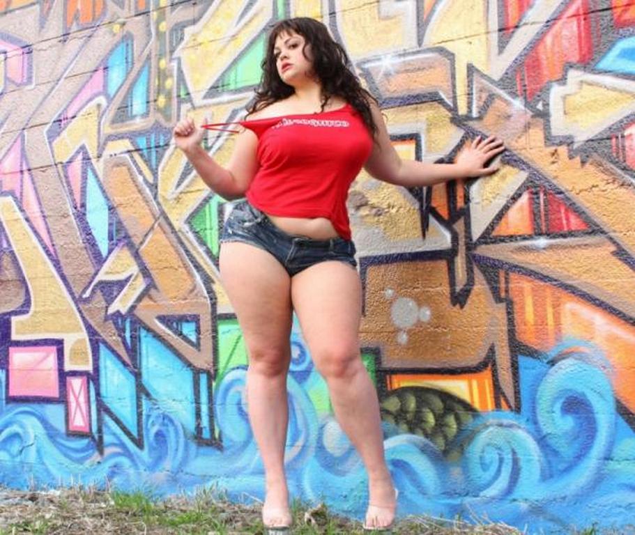 1girl breasts clothed curvy dark_hair graffiti legs outdoors posing sexy short_shorts shorts standing tagme thick thick_thighs wide_hips