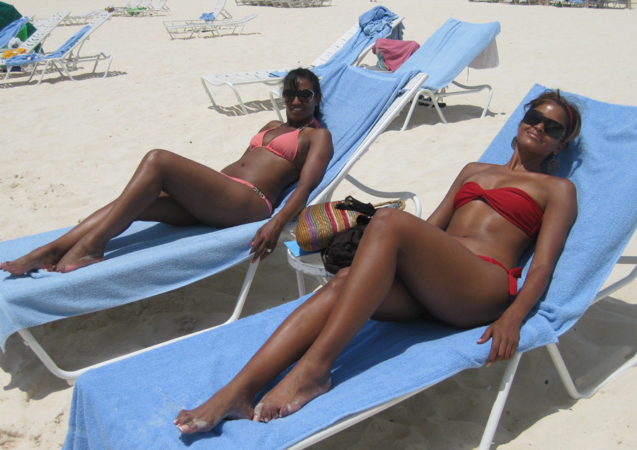 bandeau beach bikini black_hair brown_hair dark_skin halterneck headband lawn_chair lying multiple_girls on_back outside smile sunglasses swimsuit