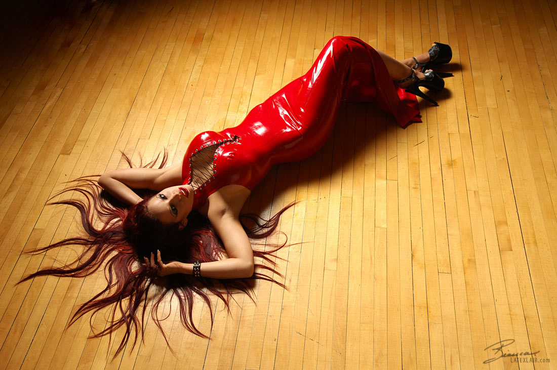 bianca_beauchamp breasts cleavage dress female high_heels large_breasts latex lipstick long_hair lying red_hair shoes solo watermark