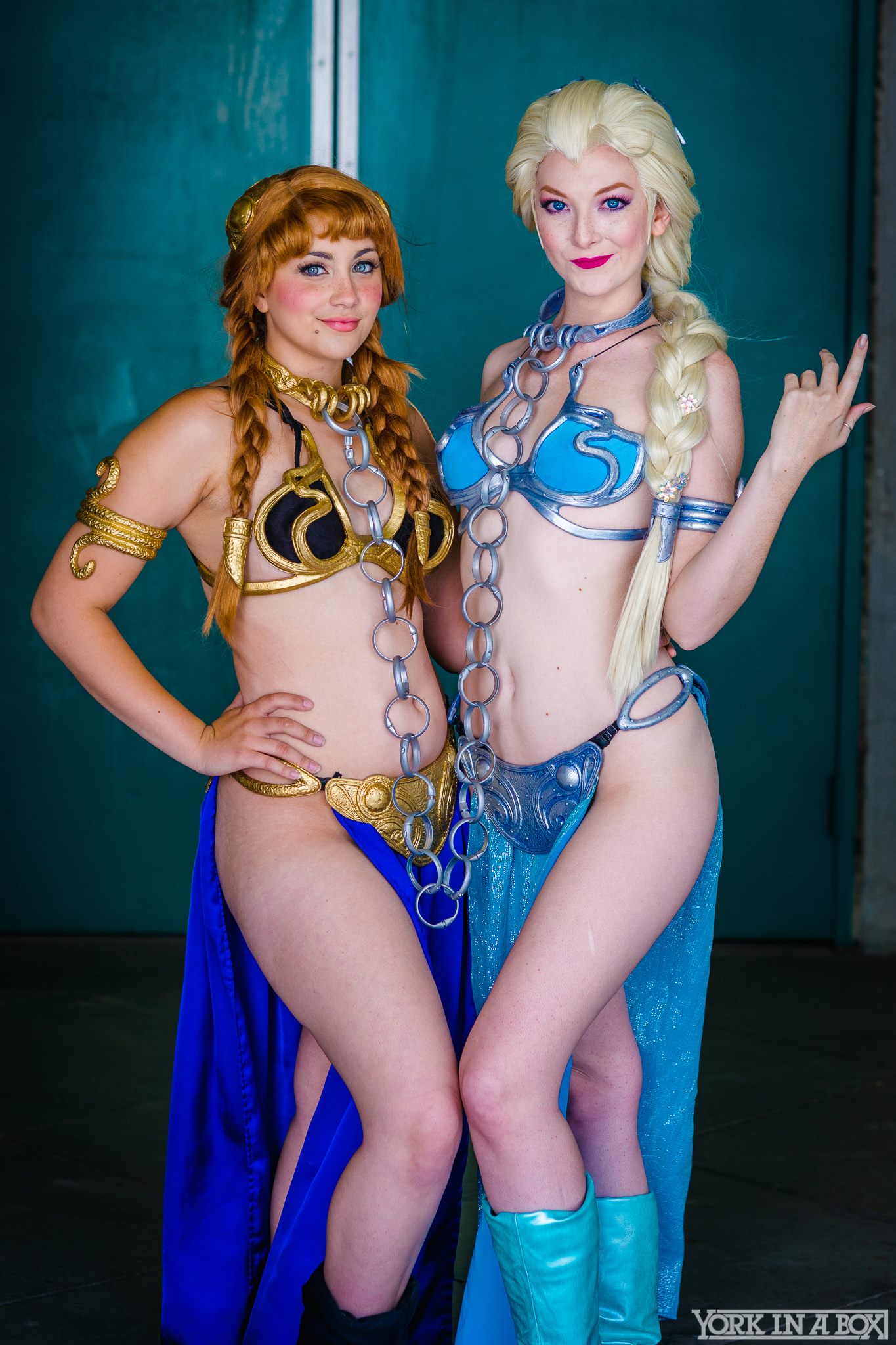 2girls anna_(frozen) bare_legs bare_shoulders blonde_hair cosplay costume elsa_(frozen) female female_only front_view frozen_(movie) lipstick looking_at_viewer make-up metal_bikini navel non_nude red_hair return_of_the_jedi slave_leia_(cosplay) smile standing star_wars thighs