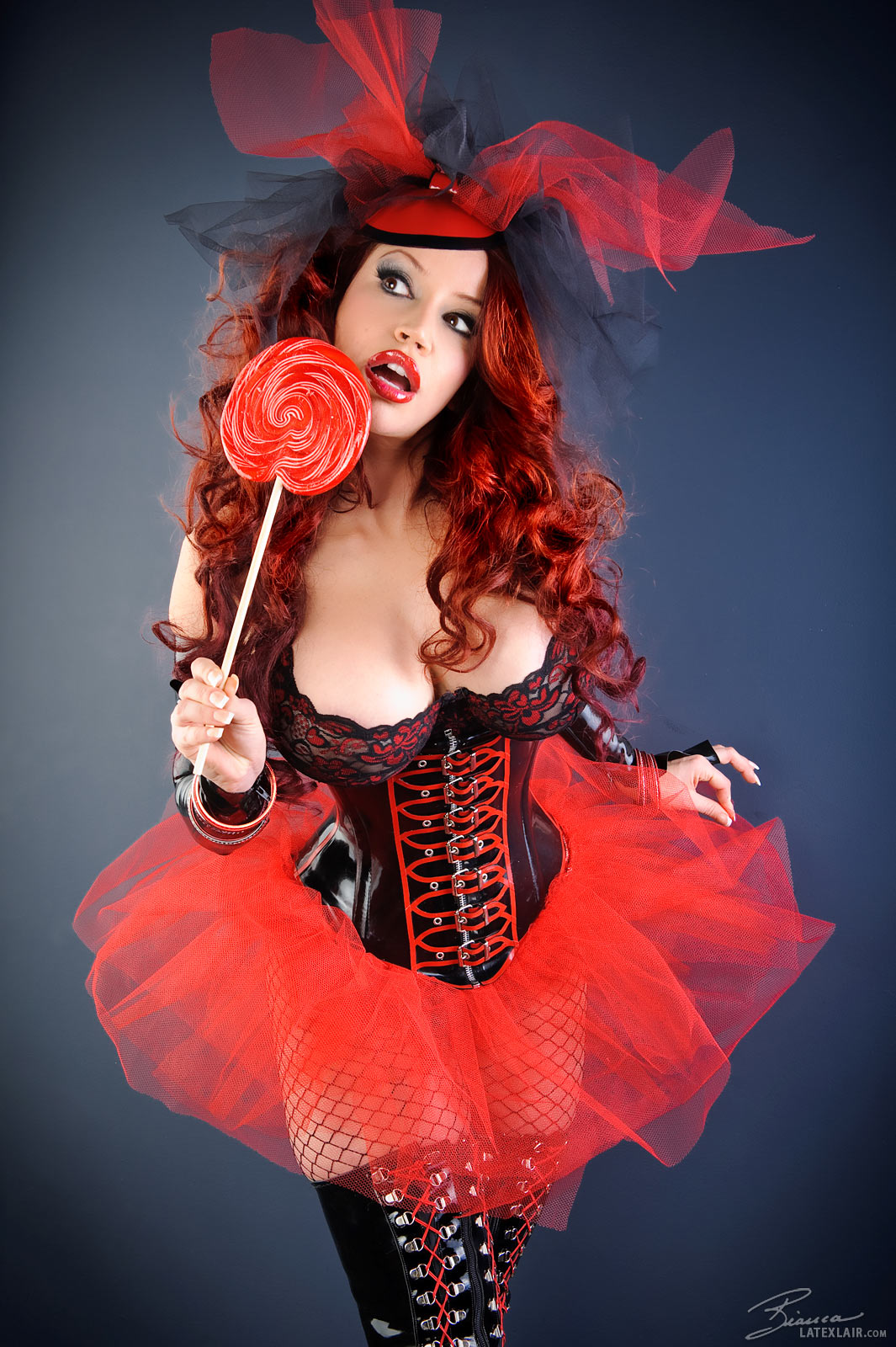 bianca_beauchamp boots breasts cleavage corset erect_nipples female fishnets large_breasts latex lipstick long_hair nipples red_hair simple_background skirt solo topless watermark