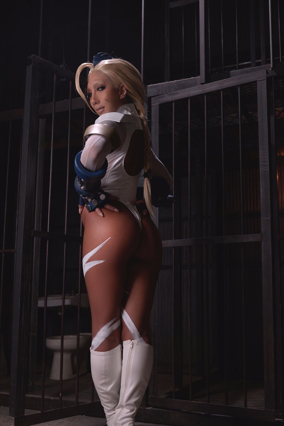1girl asian ass blonde_hair body_paint boots breasts cammy_white clothed cosplay dark_hair fake_nails female female_only gloves hands_on_hips hat high_heels knee_boots leotard long_hair looking_at_viewer looking_back non-nude nonsummerjack solo street_fighter thong thong_leotard