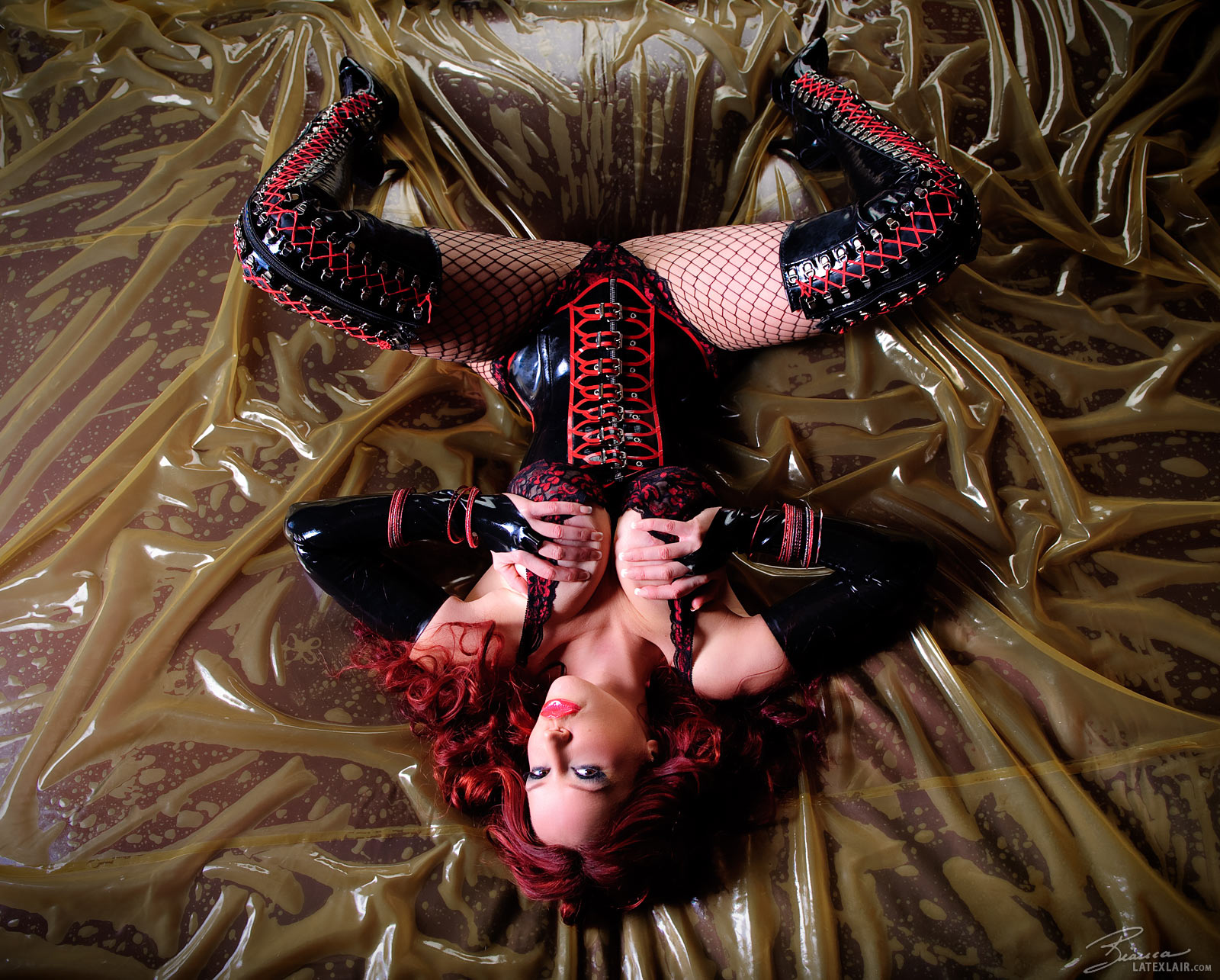 bianca_beauchamp boots breasts cleavage corset female fishnets gloves large_breasts latex long_hair lying red_hair solo watermark