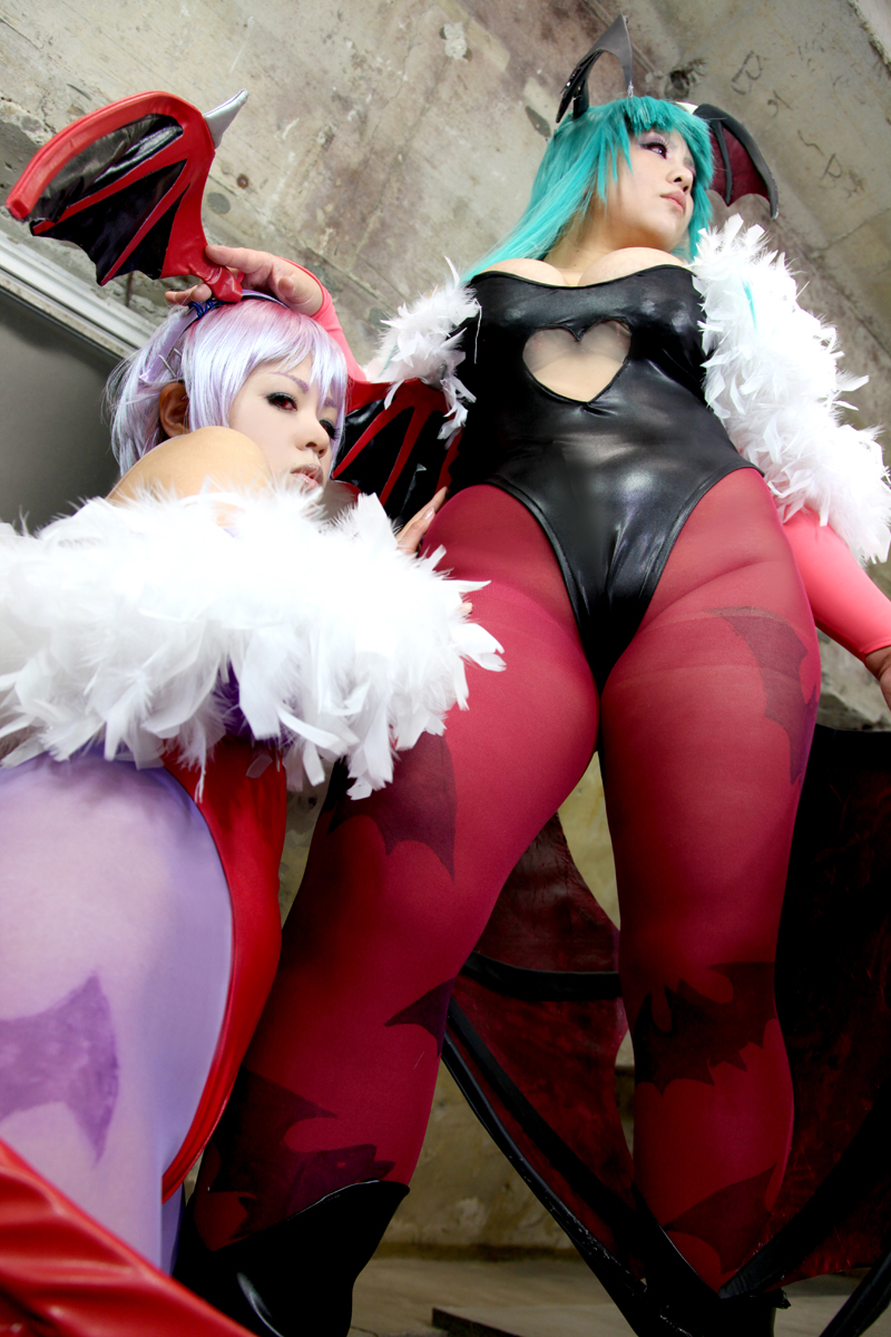 2girls aqua_hair bare_shoulders breasts chouzuki_maryou cleavage cosplay darkstalkers demon_wings female female_only huge_breasts leotard lilith_aensland long_hair looking_at_viewer looking_away morrigan_aensland non-nude pantyhose partially_clothed plump purple_hair solo succubus suzuka_itsuki thong_leotard watermark wings