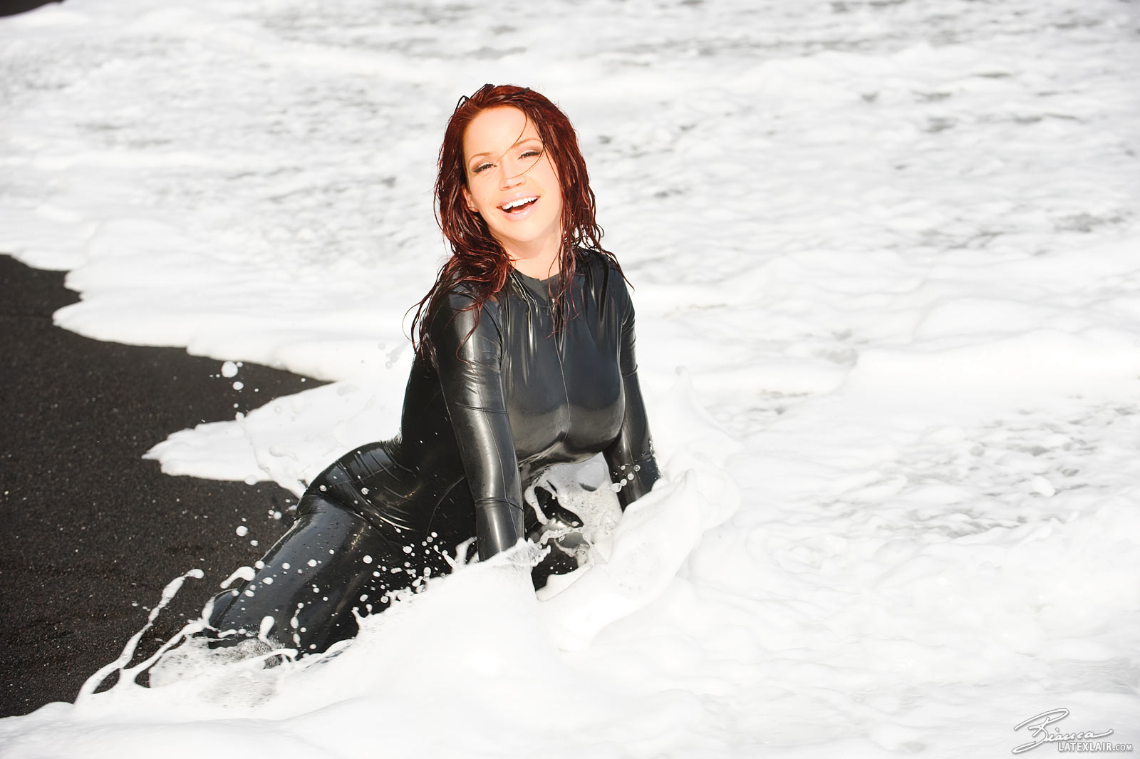 beach bianca_beauchamp breasts catsuit female gloves high_heels large_breasts latex long_hair outside red_hair sand shoes solo water watermark wet