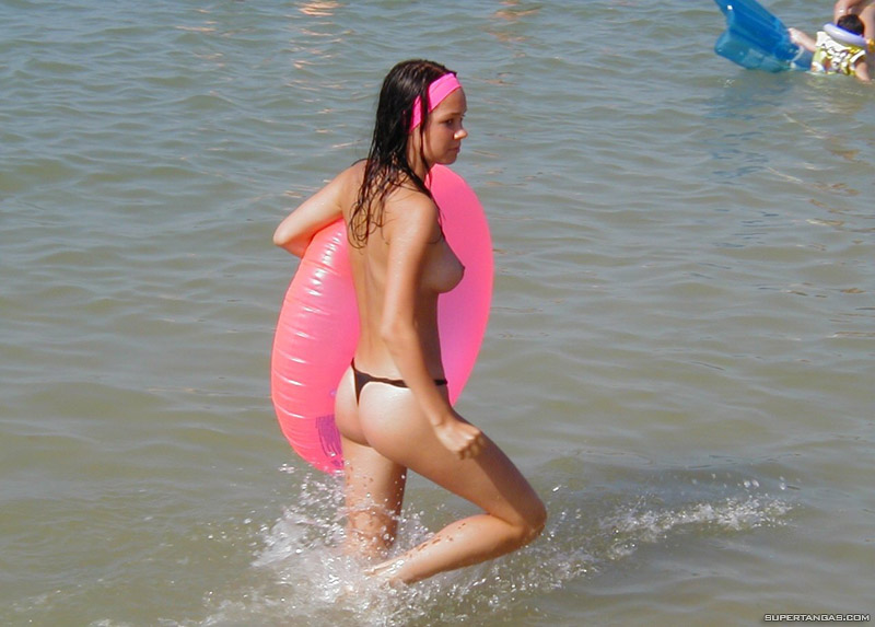ass backside beach bikini black_hair breasts headband in_water nipples outside sideboob slender thong topless wet
