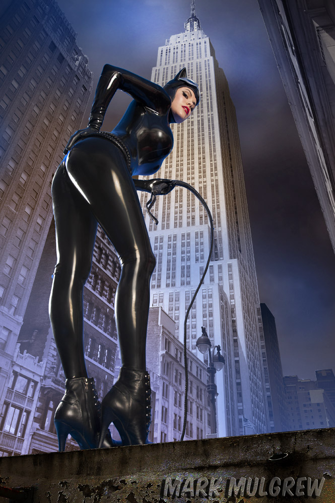 animal_ears ass batman_(series) belt bodysuit boots breasts building cat_ears catwoman catwoman_(cosplay) caucasian city dc dc_comics goggles goggles_on_head hand_on_hip high_heels latex legs looking_at_viewer looking_back looking_down mask photo real real_person selina_kyle side whip white