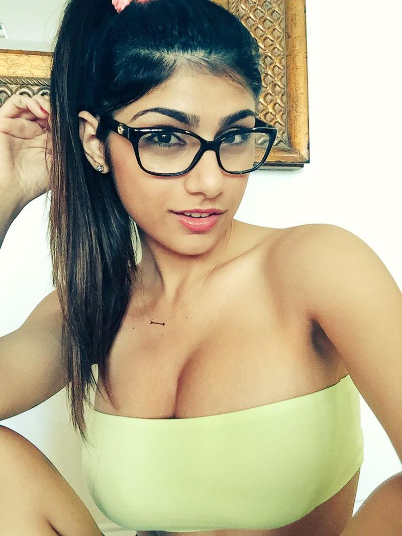 breasts brown_eyes brown_hair cleavage female glasses lebanese_american mia_khalifa solo tan_skin