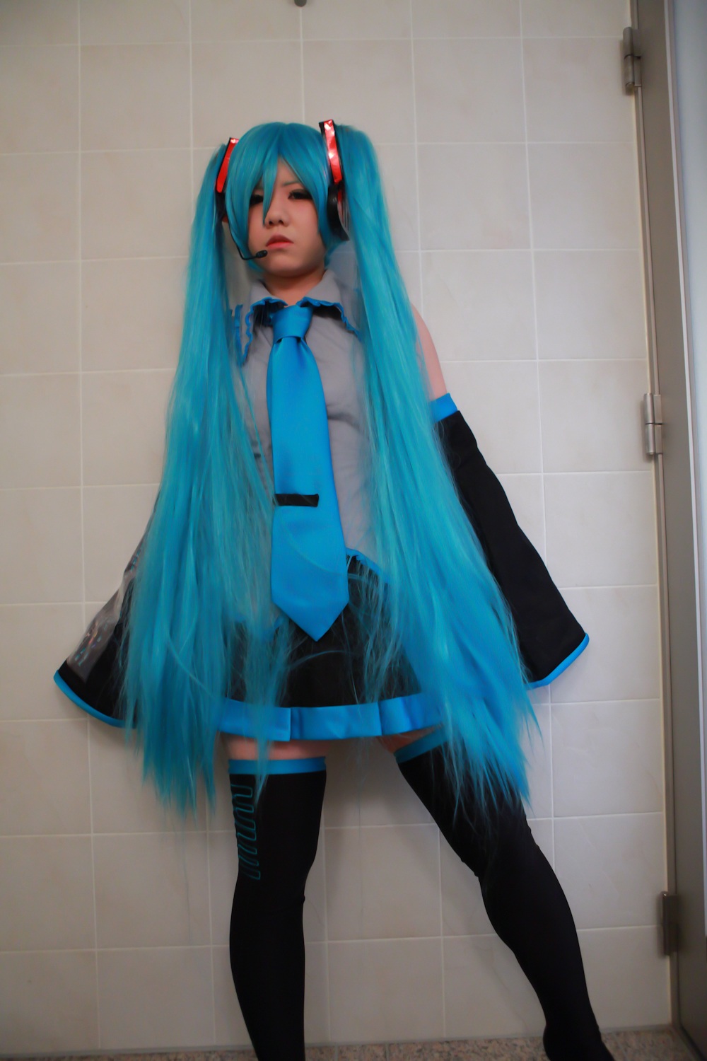 asian blue_hair breasts cosplay female headphones long_hair necktie skirt solo thighhighs