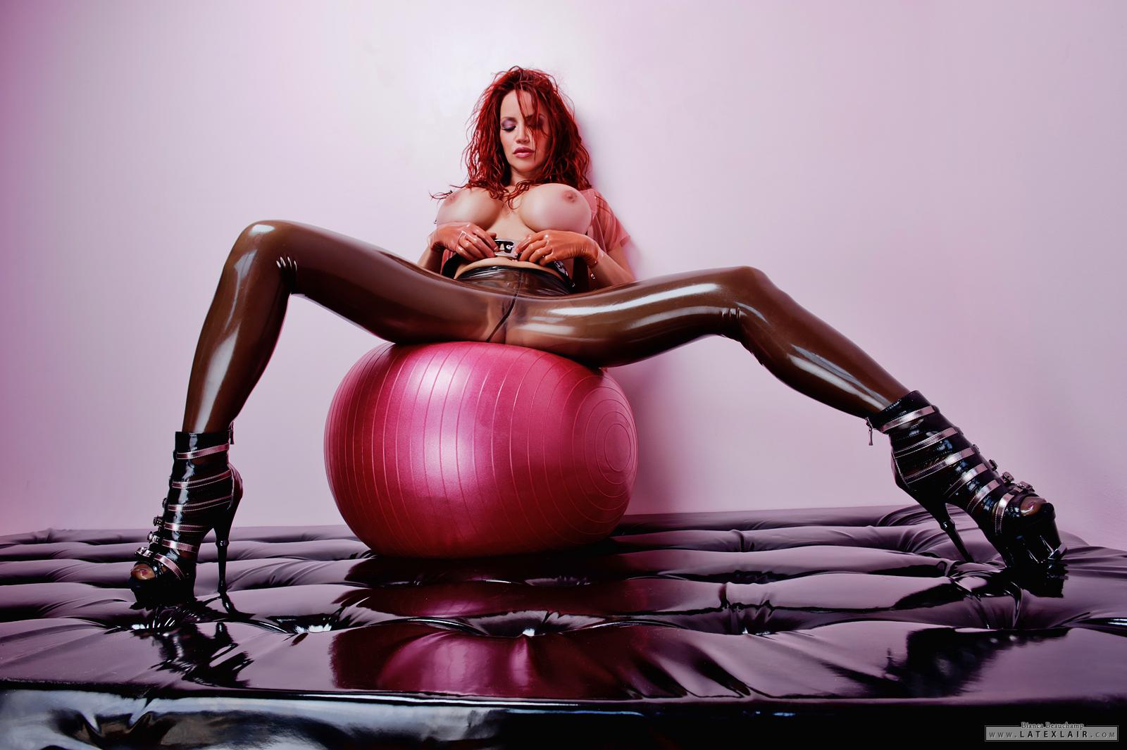 belt bianca_beauchamp breasts erect_nipples exercise_ball female large_breasts latex lipstick long_hair midriff navel navel_piercing nipples piercing pussy red_hair see-through simple_background sitting solo watermark