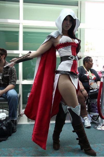 assassin assassin's_creed big_breasts boots breasts brown_hair cape cosplay hair hood long_hair photo weapon