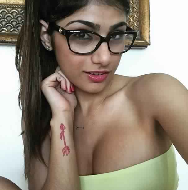 breasts brown_eyes brown_hair cleavage female glasses lebanese_american mia_khalifa solo tan_skin