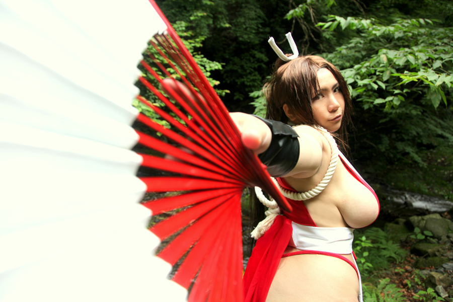 asian breasts brown_eyes brown_hair chouzuki_maryou cosplay fan female female_only hair_ornament hanging_breasts king_of_fighters large_breasts leaning_forward long_hair mai_shiranui mai_shiranui_(cosplay) plump ponytail sideboob snk solo thick_thighs thighs tied_hair very_long_hair