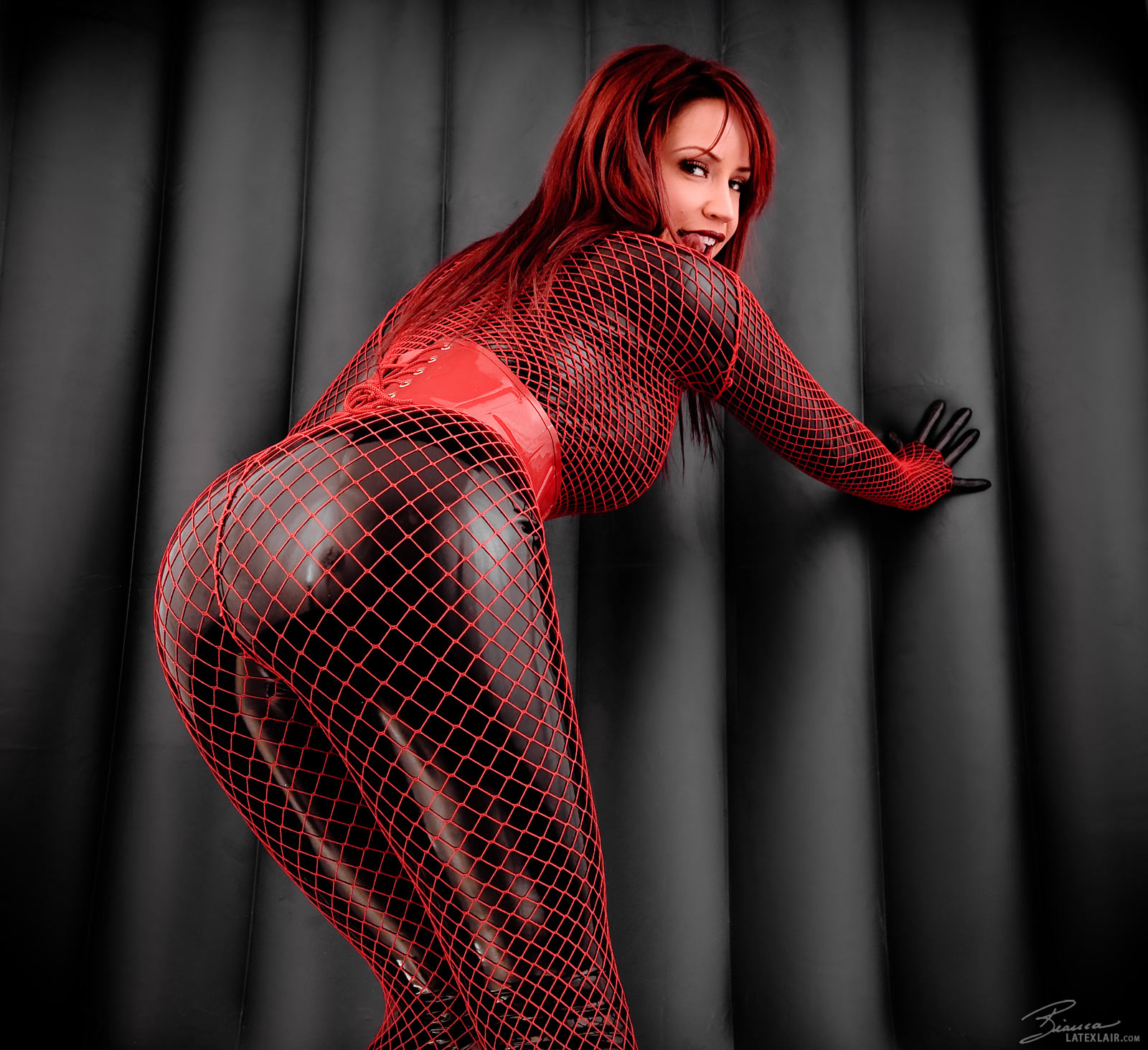 ass bianca_beauchamp breasts female large_breasts latex long_hair looking_back red_hair solo watermark