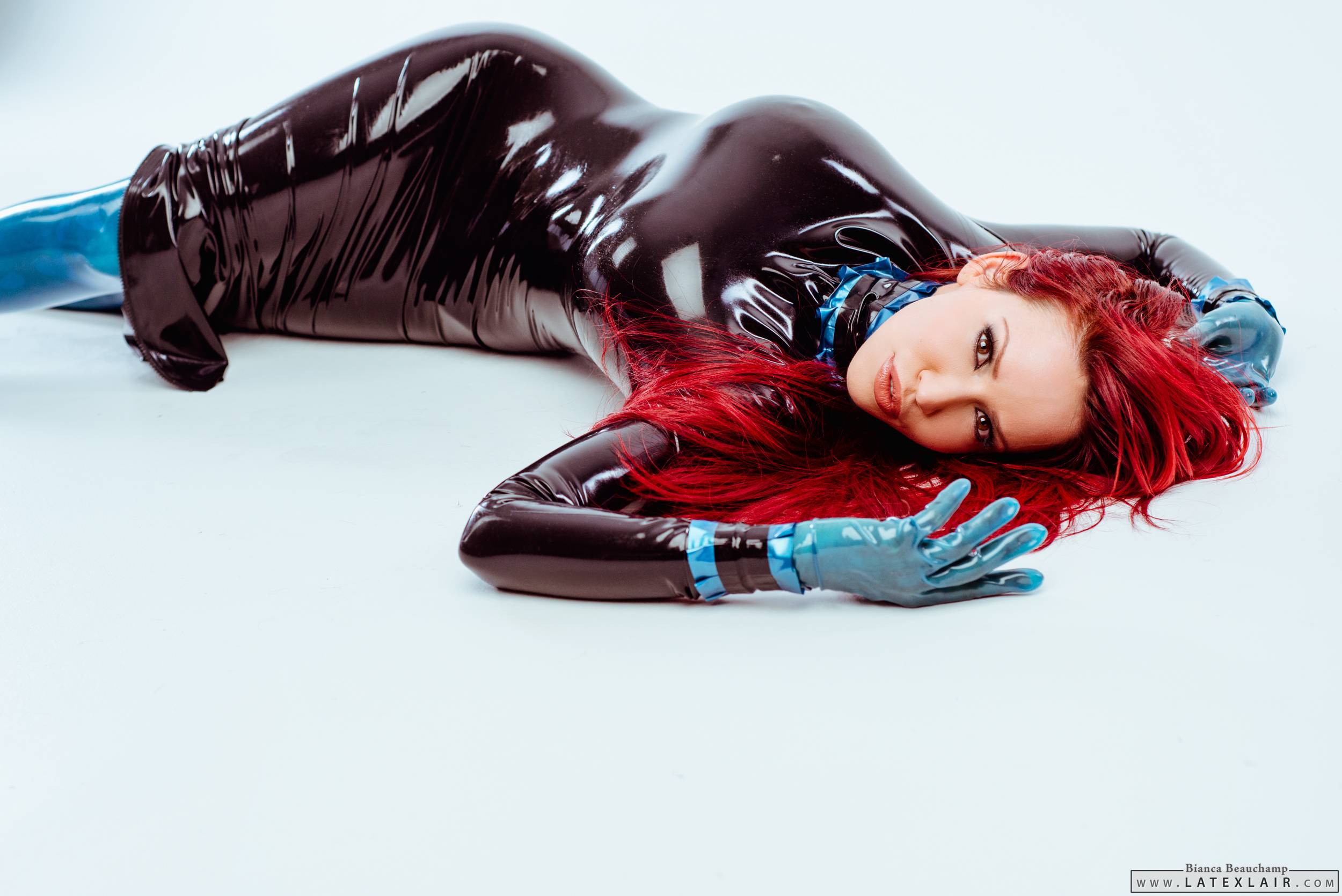 bianca_beauchamp breasts dress female gloves high_heels large_breasts latex long_hair lying red_hair shoes simple_background solo