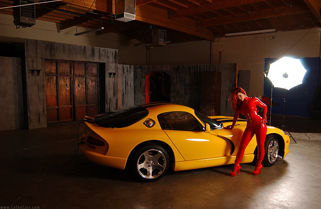 bianca_beauchamp breasts car catsuit female large_breasts long_hair red_hair solo watermark