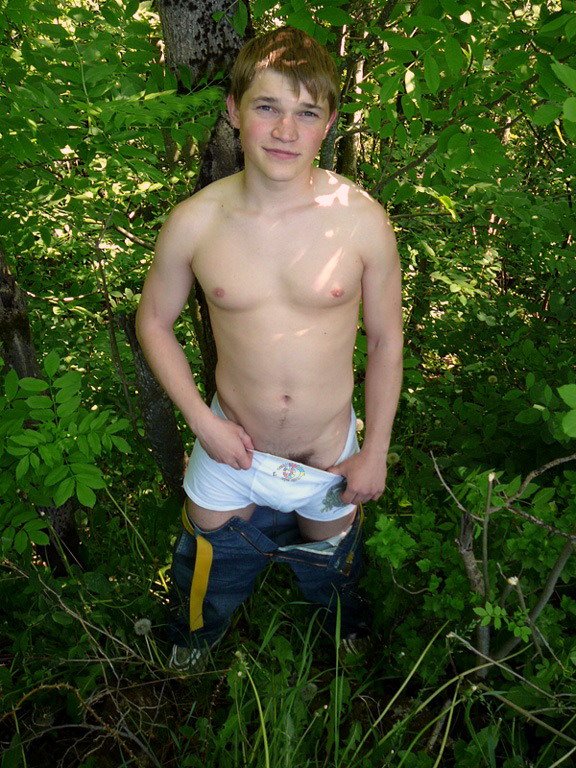 1_boy 1_male 1boy blush brown_hair bulge clothed hair human human_only jeans looking_at_viewer male male_human male_only navel outdoors pants_down panty_pull photo pubic_hair real_person short_hair shorts smile solo standing topless tree