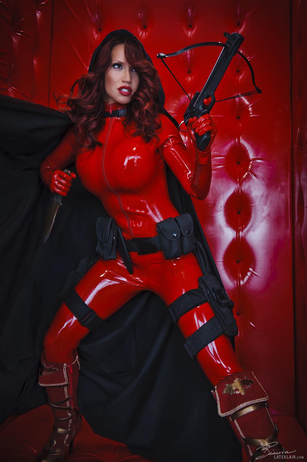 bianca_beauchamp bodysuit boots breasts cape female gloves gun high_heels hood knife large_breasts latex long_hair red_hair solo watermark weapon