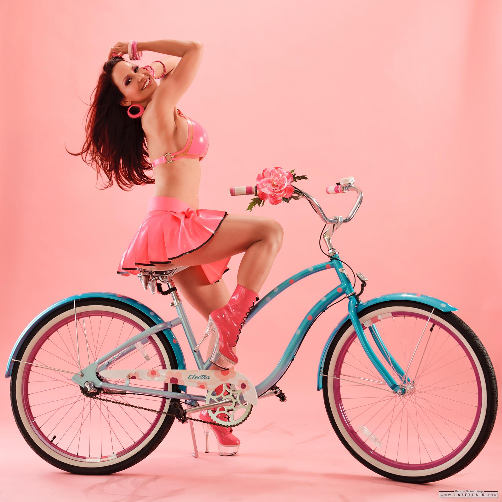 bianca_beauchamp bicycle breasts cleavage female high_heels large_breasts long_hair midriff navel navel_piercing necklace piercing ponytail red_hair shoes solo watermark