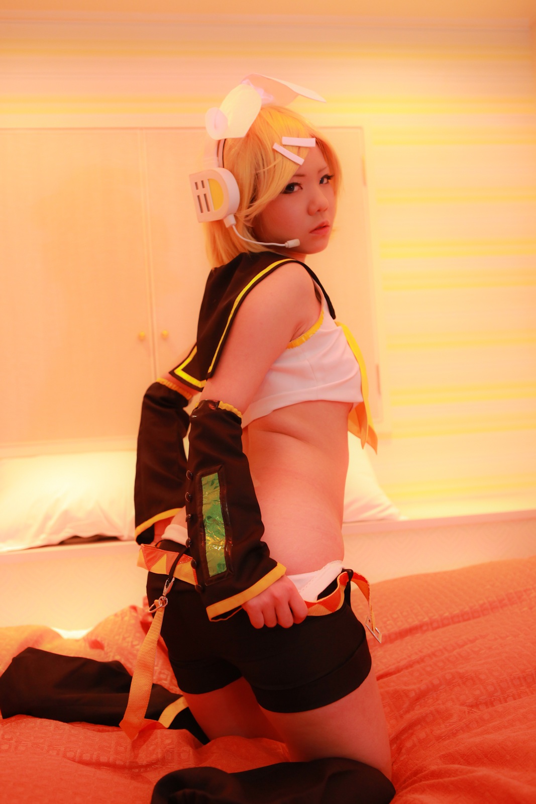 asian ass bed blonde_hair breasts cosplay female headphones kagamine_rin looking_back midriff navel panties short_hair shorts solo vocaloid