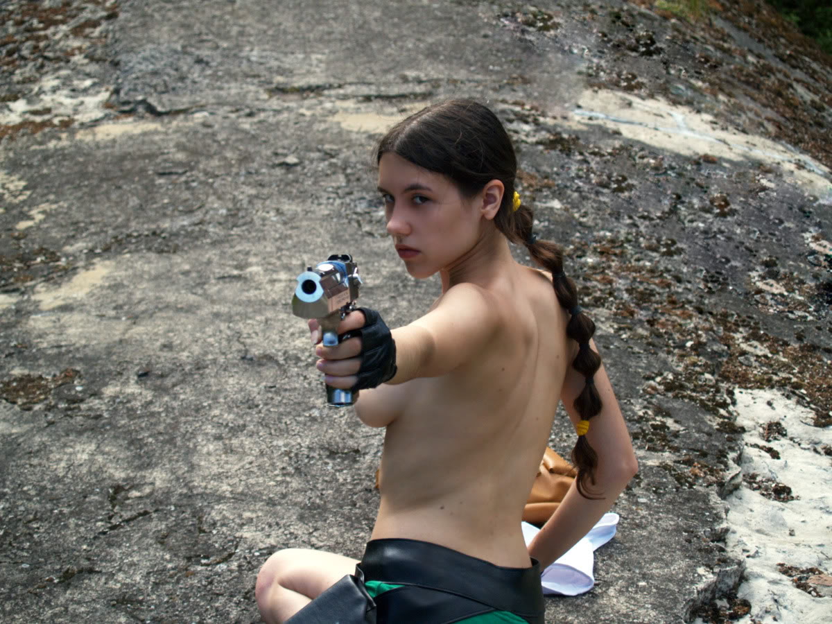 braid breasts cosplay female gloves gun lara_croft looking_back photo tied_hair tomb_raider topless weapon