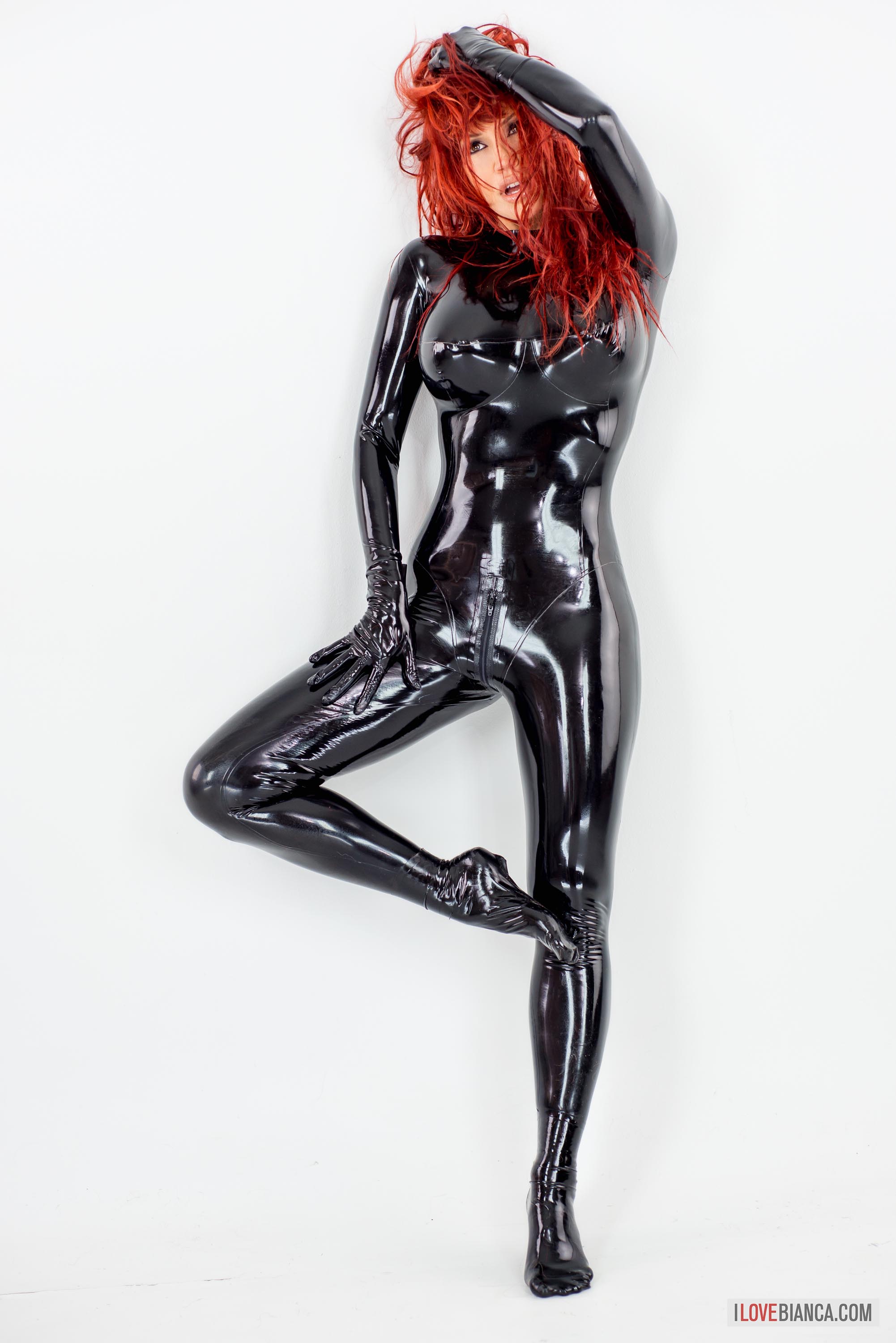 bianca_beauchamp breasts catsuit female gloves large_breasts latex long_hair red_hair simple_background solo watermark