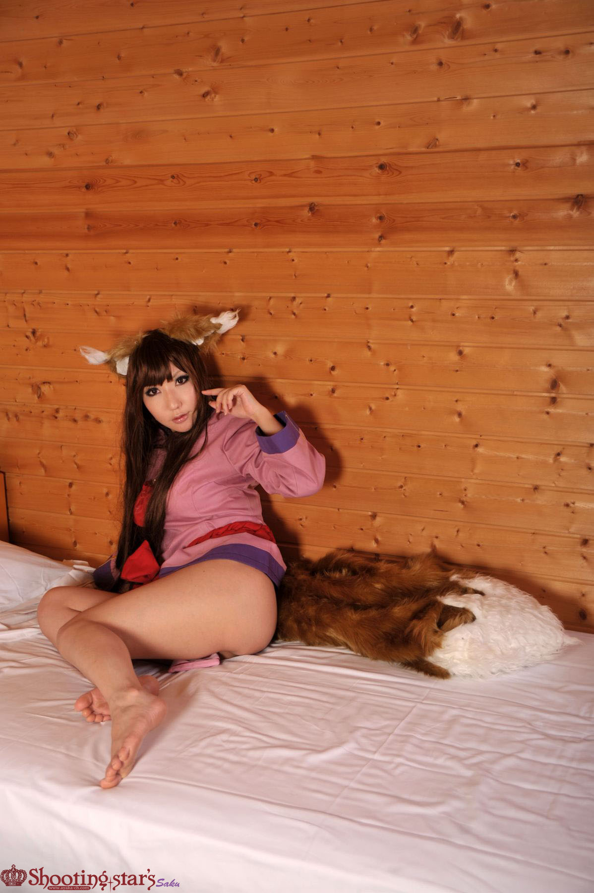 1girl animal_ears asian bed brown_hair clothed cosplay feet female female_only holo long_hair looking_at_viewer non-nude on_bed shooting_star solo spice_and_wolf tan_skin watermark