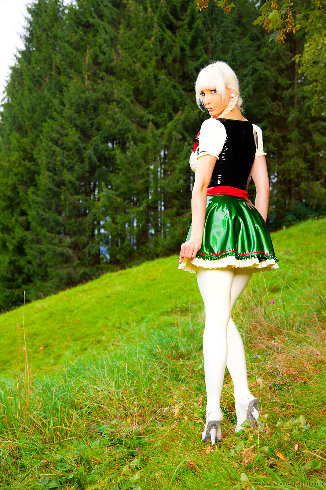 ass blonde_hair breasts corset female high_heels large_breasts latex long_hair looking_back outside shoes skirt solo susan_wayland watermark