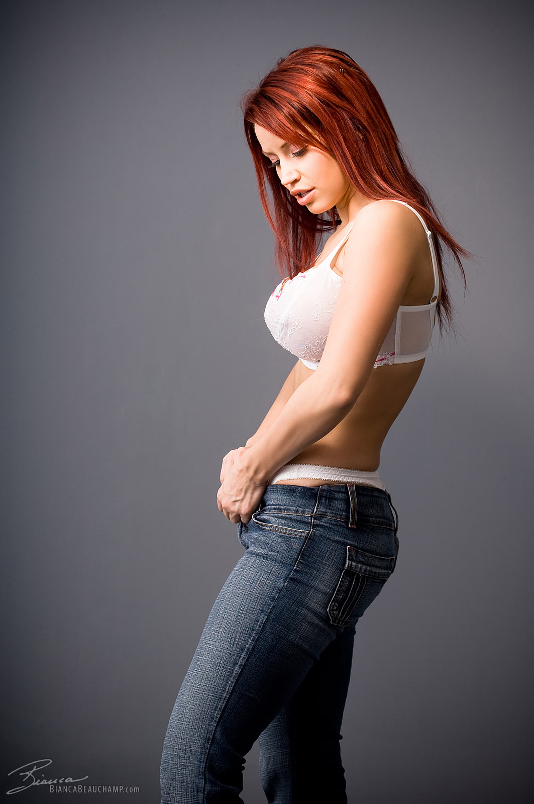 bianca_beauchamp breasts female jeans large_breasts long_hair red_hair simple_background solo watermark