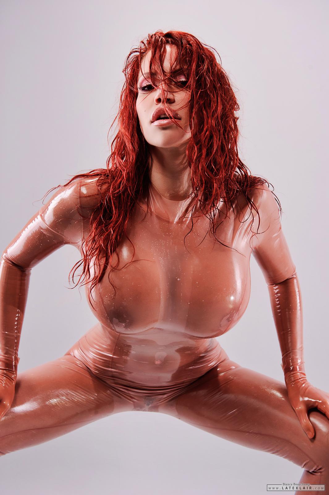 bianca_beauchamp breasts catsuit erect_nipples female gloves large_breasts latex long_hair navel navel_piercing nipples piercing red_hair see-through simple_background solo watermark