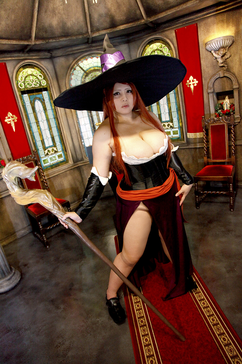 asian breasts brown_hair chouzuki_maryou cleavage cosplay female hat huge_breasts long_hair shoes solo sorceress_(dragon's_crown)_(cosplay) staff witch_hat