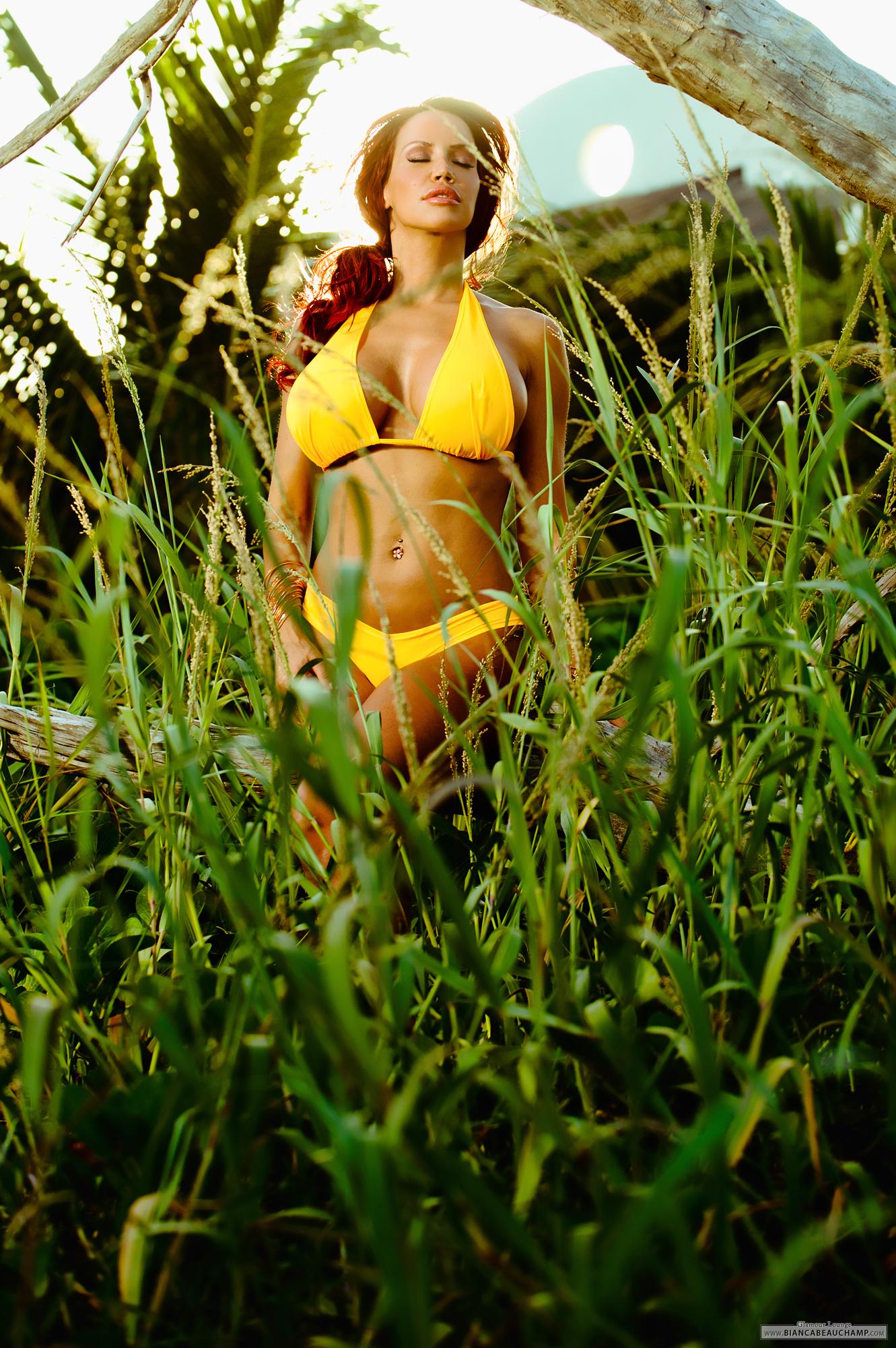 bianca_beauchamp bikini breasts cleavage eyes_closed female grass large_breasts long_hair midriff navel navel_piercing outside piercing red_hair solo
