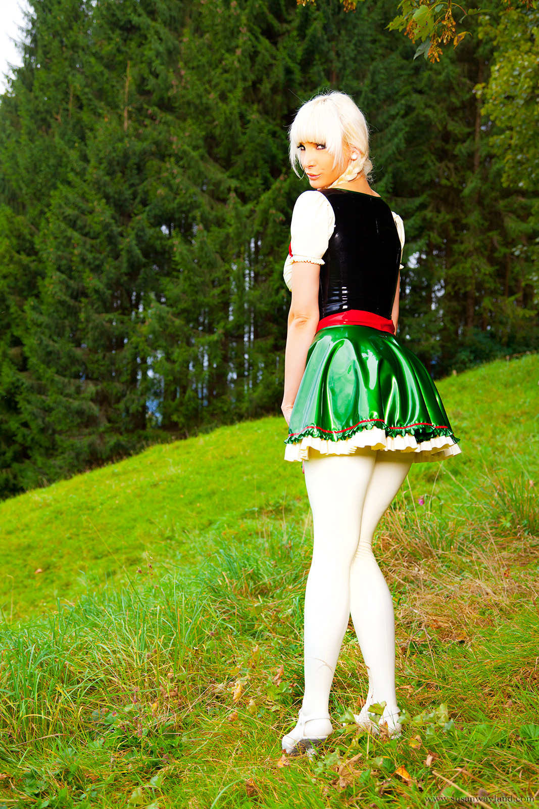 ass blonde_hair breasts corset female high_heels large_breasts latex long_hair looking_back outside shoes skirt solo susan_wayland watermark