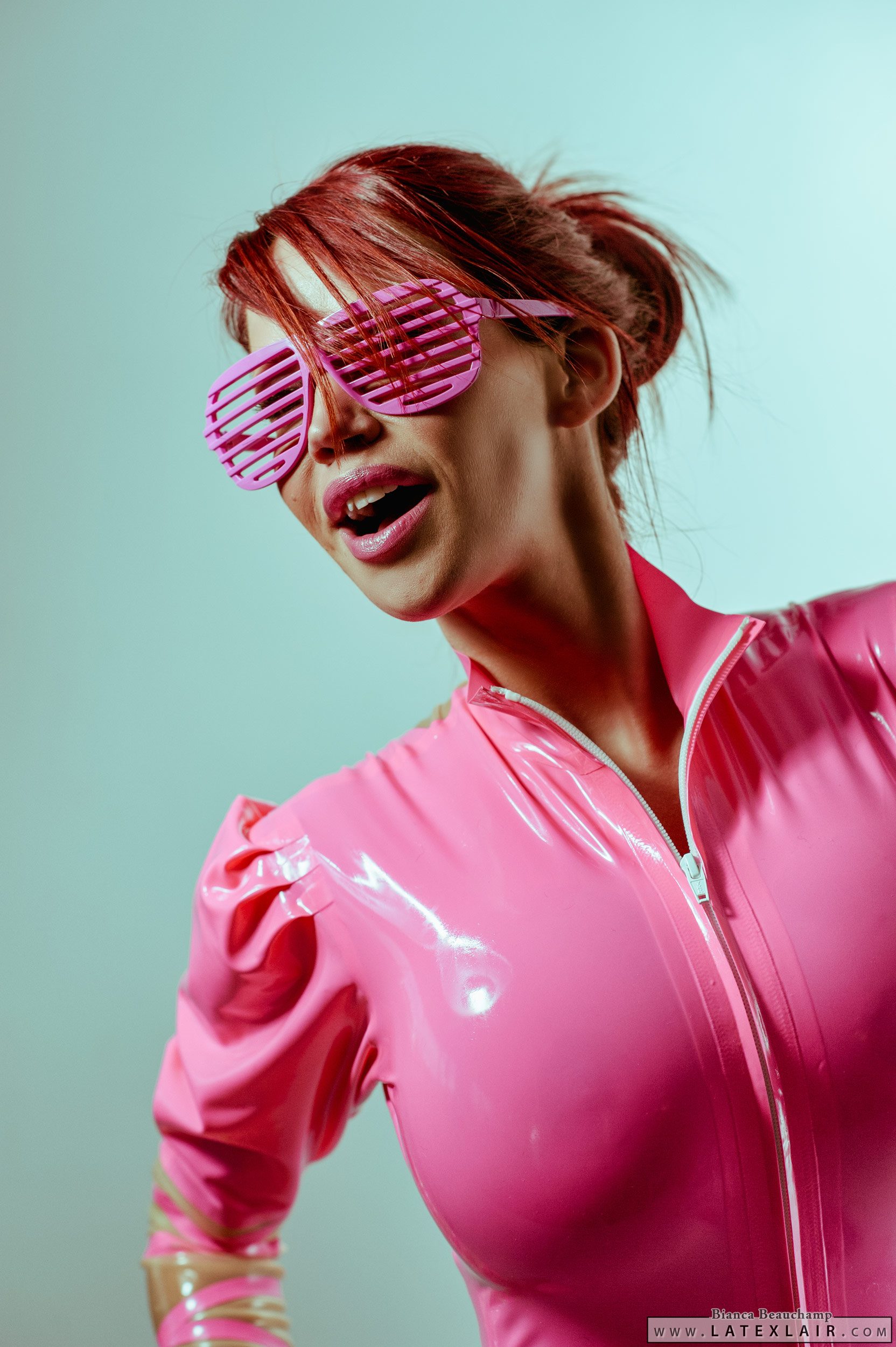 bianca_beauchamp breasts female large_breasts latex long_hair open_mouth red_hair simple_background solo watermark