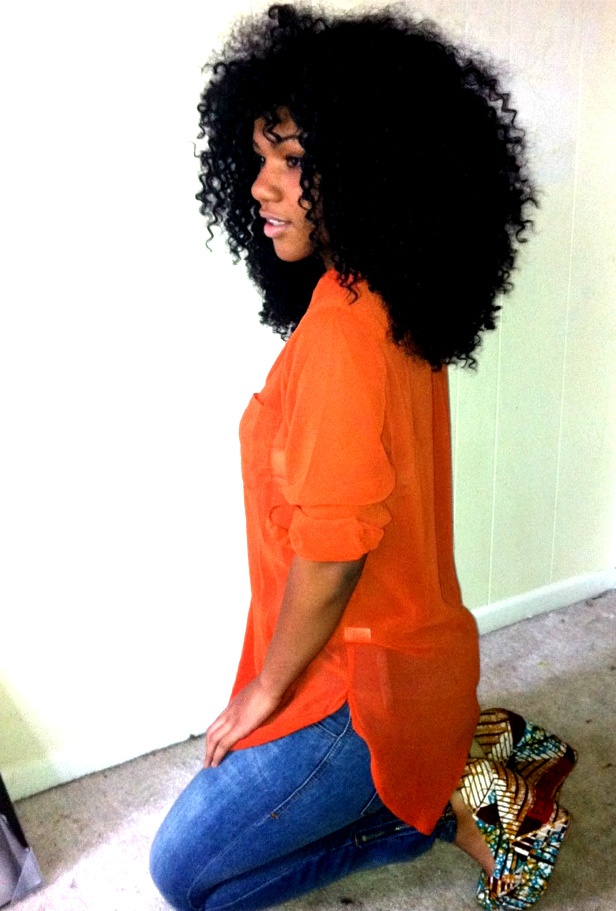 afro black_hair blouse curly_hair dark_skin female from_side heels jeans kneeling long_hair solo