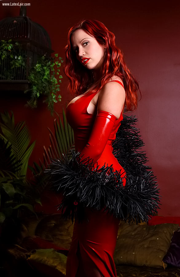 bianca_beauchamp breasts cleavage dress female high_heels large_breasts latex lipstick long_hair red_hair shoes sofa solo watermark