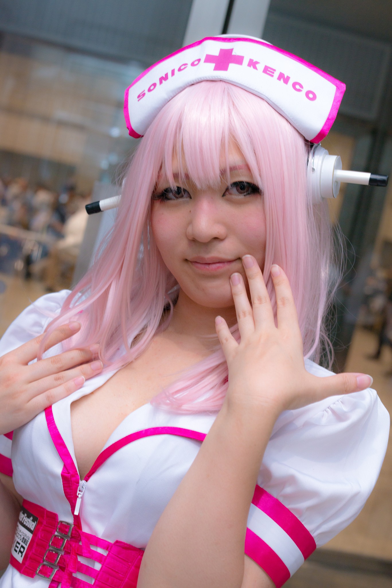 1girl asian breasts cosplay dress female headphones japanese long_hair nurse pink_hair solo super_sonico