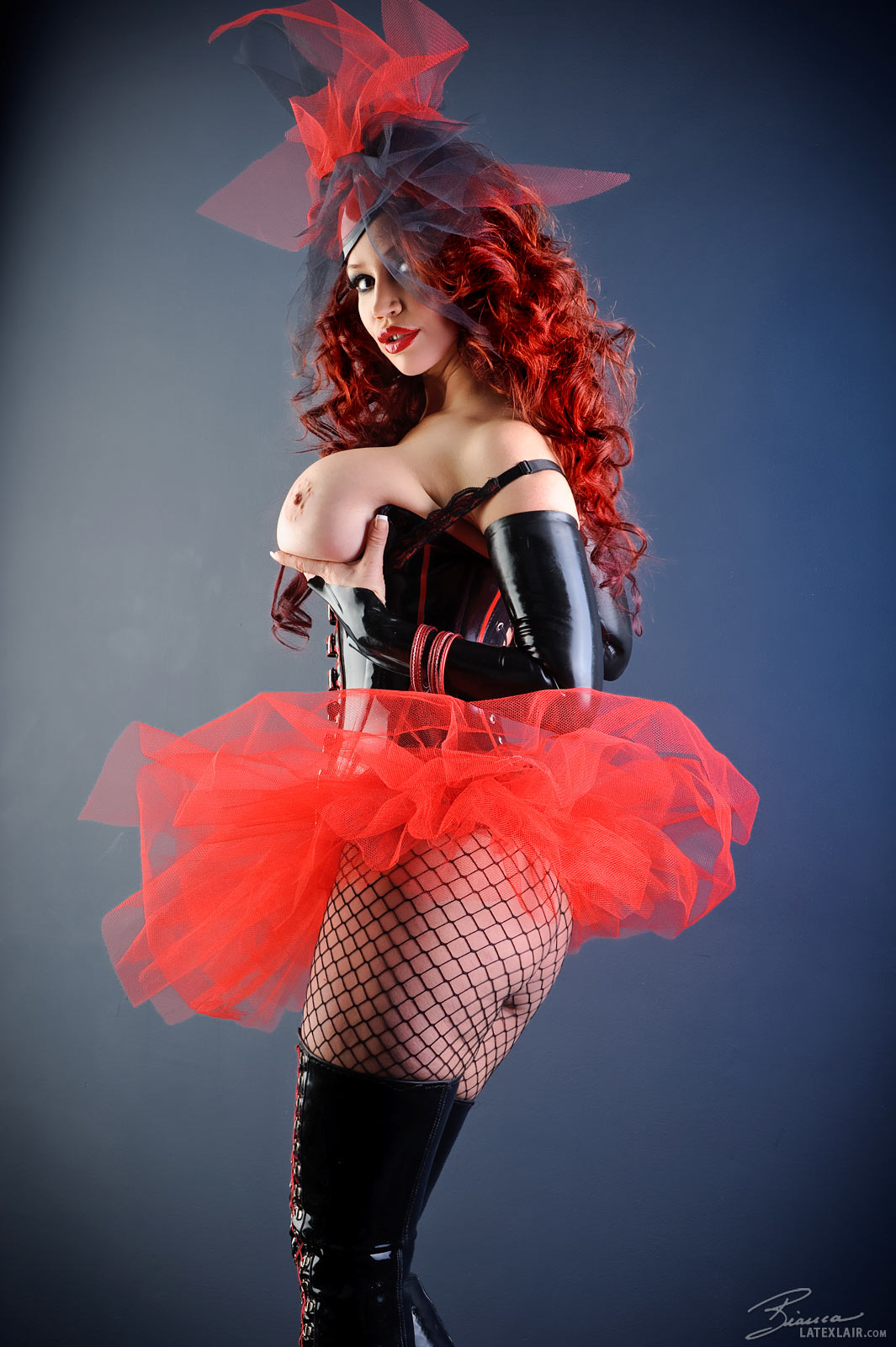 bianca_beauchamp boots breasts cleavage corset erect_nipples female fishnets large_breasts latex lipstick long_hair nipples red_hair simple_background skirt solo topless watermark