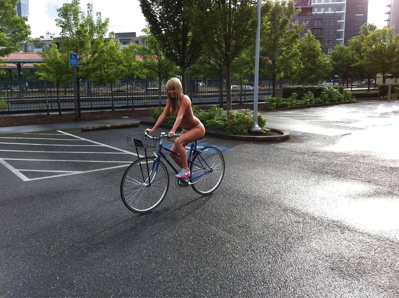 bicycle blonde_hair long_hair outside parking_lot riding sara_jean_underwood slender smile topless