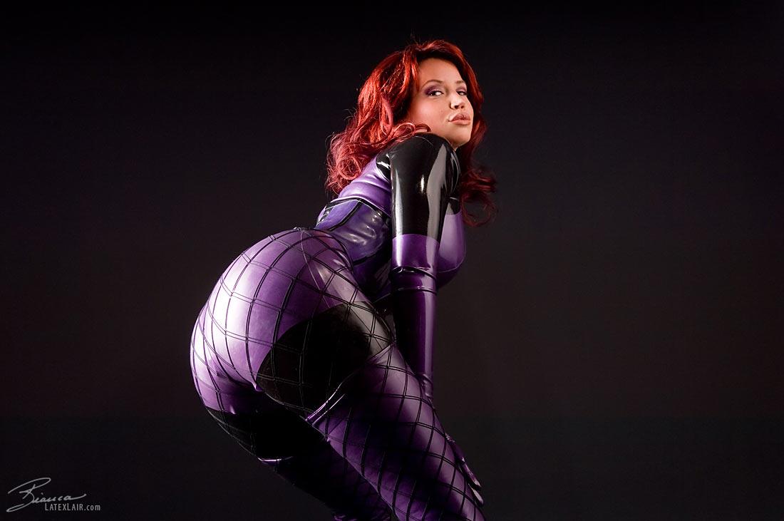 ass bianca_beauchamp breasts catsuit female gloves large_breasts latex long_hair looking_back red_hair simple_background solo watermark