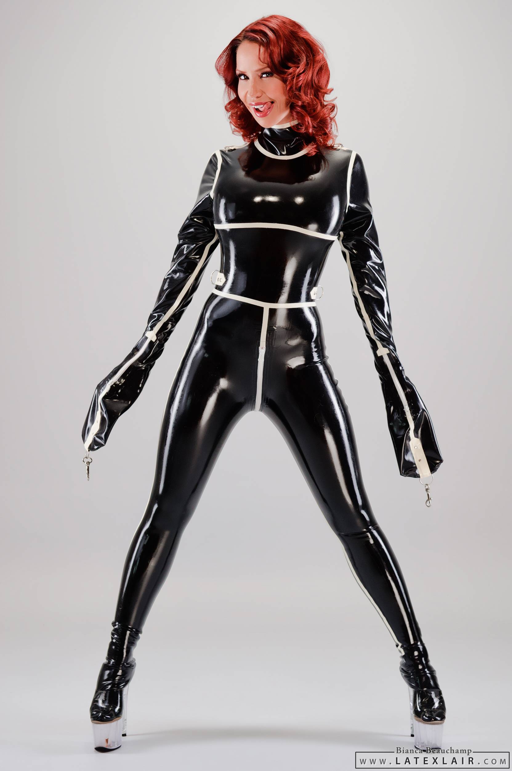 bianca_beauchamp breasts catsuit female large_breasts latex long_hair red_hair simple_background solo watermark