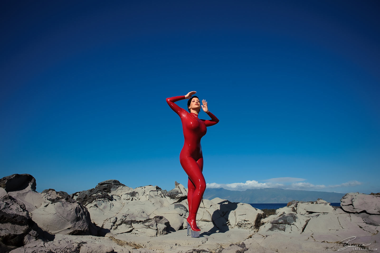 bianca_beauchamp breasts catsuit female gloves high_heels large_breasts latex long_hair outside red_hair shoes solo watermark