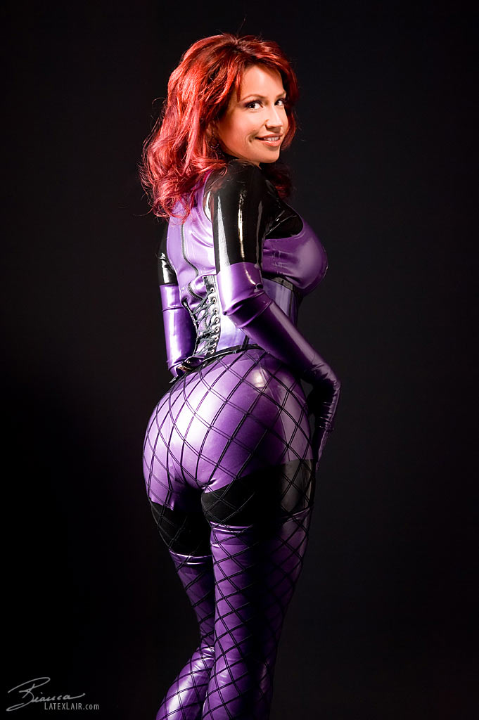 ass bianca_beauchamp breasts catsuit female gloves large_breasts latex long_hair looking_back red_hair simple_background solo watermark